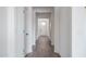 Bright hallway with wood-look floors leads to a door with glass panels at 12722 W Luxton Ln, Avondale, AZ 85323