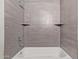 Clean bathroom with gray tile, built-in shelves, and a bathtub at 1682 W Campbell Ave, Phoenix, AZ 85015