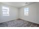 Simple bedroom with carpet, two windows, and light gray walls at 17219 W Vacaville St, Surprise, AZ 85388