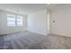 Neutral bedroom featuring plush carpet, two windows, and light gray walls at 17219 W Vacaville St, Surprise, AZ 85388