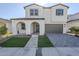 Two-story home featuring a gray brick driveway, manicured lawn, and covered entryway at 17219 W Vacaville St, Surprise, AZ 85388