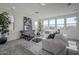 Sun-filled living room features a large window, neutral paint and carpet, and modern decor at 17219 W Vacaville St, Surprise, AZ 85388