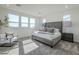 Bright main bedroom featuring large windows, a king-sized bed and a neutral color palette at 17219 W Vacaville St, Surprise, AZ 85388