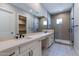 Elegant bathroom with double vanity, frameless shower, and patterned tile at 17380 W Carlisle Dr, Surprise, AZ 85388