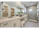 A well-lit bathroom featuring a large vanity, patterned floor, and glass shower at 17380 W Carlisle Dr, Surprise, AZ 85388