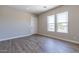 Well-lit bedroom featuring wood-look floors and large windows at 17380 W Carlisle Dr, Surprise, AZ 85388