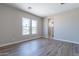 Bright bedroom with wood-look tile floors and two large windows at 17380 W Carlisle Dr, Surprise, AZ 85388