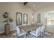 Elegant dining room with modern decor, a vaulted ceiling, and an adjacent kitchen area at 17380 W Carlisle Dr, Surprise, AZ 85388