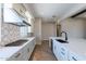 Modern kitchen with white cabinets, gas cooktop and herringbone floors at 17380 W Carlisle Dr, Surprise, AZ 85388