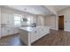 Modern kitchen with white cabinets, quartz countertops, and herringbone flooring at 17380 W Carlisle Dr, Surprise, AZ 85388