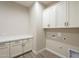 A bright laundry room with upper and lower cabinets, providing ample storage space at 17380 W Carlisle Dr, Surprise, AZ 85388