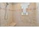 Large shower with stone tile, built-in seat, and glass block accents at 17459 N 79Th St, Scottsdale, AZ 85255