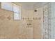 Clean shower with stone tile, built-in shelving, and glass block wall at 17459 N 79Th St, Scottsdale, AZ 85255