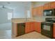 Kitchen boasts wood cabinets, black appliances, and a breakfast bar at 1933 S Peppertree Dr, Gilbert, AZ 85295