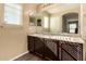 Double sink bathroom vanity with dark wood cabinets and a large mirror at 1940 N 78Th Gln, Phoenix, AZ 85035