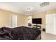 Main bedroom with large TV, ensuite bathroom access, and neutral wall colors at 1940 N 78Th Gln, Phoenix, AZ 85035