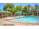 Refreshing community pool with palm trees and shaded seating areas at 1940 N 78Th Gln, Phoenix, AZ 85035