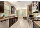 Well-lit kitchen featuring dark wood cabinets and stainless steel appliances at 1940 N 78Th Gln, Phoenix, AZ 85035