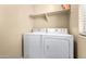 Convenient laundry room with washer, dryer, and overhead shelving at 1940 N 78Th Gln, Phoenix, AZ 85035