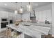 Modern kitchen island with marble countertop, white shaker cabinets and pendant lighting at 22852 E Thornton Rd, Queen Creek, AZ 85142