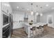 Modern kitchen with island, seating, white cabinets, and marble countertops at 22852 E Thornton Rd, Queen Creek, AZ 85142