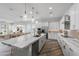 Modern kitchen with expansive island, white cabinets, and marble countertops at 22852 E Thornton Rd, Queen Creek, AZ 85142