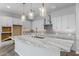 Modern kitchen with large island, white cabinetry, and marble countertops at 22852 E Thornton Rd, Queen Creek, AZ 85142