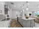 Modern kitchen with large island, white cabinets and marble countertops at 22852 E Thornton Rd, Queen Creek, AZ 85142