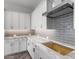 Kitchen detail showcasing gray tile backsplash and white cabinets at 22852 E Thornton Rd, Queen Creek, AZ 85142