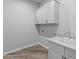 Laundry room with white cabinets, a sink, and overhead storage at 22852 E Thornton Rd, Queen Creek, AZ 85142