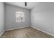 Simple bedroom with wood-look floors and window at 22878 E Carriage Way, Queen Creek, AZ 85142