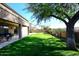 Landscaped backyard with grassy area and mature shade tree at 3267 E Maplewood St, Gilbert, AZ 85297