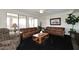 Living room with two leather sofas, a coffee table, and large windows at 3267 E Maplewood St, Gilbert, AZ 85297