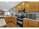 Modern kitchen with wood cabinets and stainless steel appliances at 3436 E Vaughn Ave, Gilbert, AZ 85234