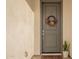 Gray front door with a fall-themed wreath and welcome mat at 3515 N Tewa Cir, Eloy, AZ 85131