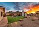 Expansive backyard with lush lawn, patio, rock features, and desert landscaping under a vibrant sky at 4022 E Stanford Dr, Phoenix, AZ 85018