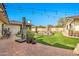 Backyard with a beautiful rock waterfall feature, covered patio, and manicured lawn at 4022 E Stanford Dr, Phoenix, AZ 85018