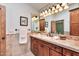 Bathroom featuring a vanity with a sink, tiled backsplash, and warm lighting at 4022 E Stanford Dr, Phoenix, AZ 85018