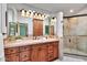 Bathroom featuring a vanity with a sink, a tiled shower, and warm lighting at 4022 E Stanford Dr, Phoenix, AZ 85018