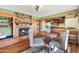 Cozy dining area with a brick fireplace, rustic table, and views into the adjacent kitchen at 4022 E Stanford Dr, Phoenix, AZ 85018