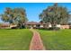 Lovely single-story home featuring a brick pathway leading through a lush green lawn and mature trees at 4022 E Stanford Dr, Phoenix, AZ 85018