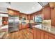A shot of the kitchen with stainless steel appliances, wood cabinets, granite countertops, and hardwood floors at 4022 E Stanford Dr, Phoenix, AZ 85018