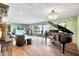 Elegant living room featuring a grand piano, chandelier, and sliding doors to the outdoor area at 4022 E Stanford Dr, Phoenix, AZ 85018