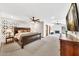 Spacious main bedroom featuring carpeted floors, a ceiling fan, and access to an attached sitting area with a fireplace at 4022 E Stanford Dr, Phoenix, AZ 85018