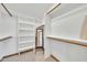 Bright walk-in closet with multiple shelves and wood trim on the walls at 4022 E Stanford Dr, Phoenix, AZ 85018