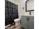 Updated bathroom with gray vanity, black fixtures, and patterned shower curtain at 409 W Pontiac Dr # 8, Phoenix, AZ 85027