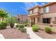 Exterior view of townhomes with walkway, desert landscaping, and blue sky backdrop at 42424 N Gavilan Peak Pkwy # 23102, Anthem, AZ 85086