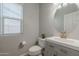 Small bathroom with gray vanity, oval mirror, and white toilet at 4627 S Grenoble Cir, Mesa, AZ 85212