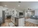 Kitchen island with white cabinets, stainless steel dishwasher, and view of dining area at 4627 S Grenoble Cir, Mesa, AZ 85212