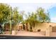 Tan stucco house with a large front yard and mature trees at 4706 E Rancho Caliente Dr, Cave Creek, AZ 85331